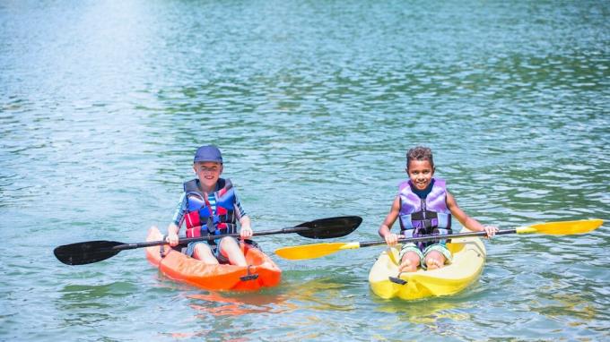 Twee jongens kajakken op een meer als onderdeel van een zomerkamp activiteit